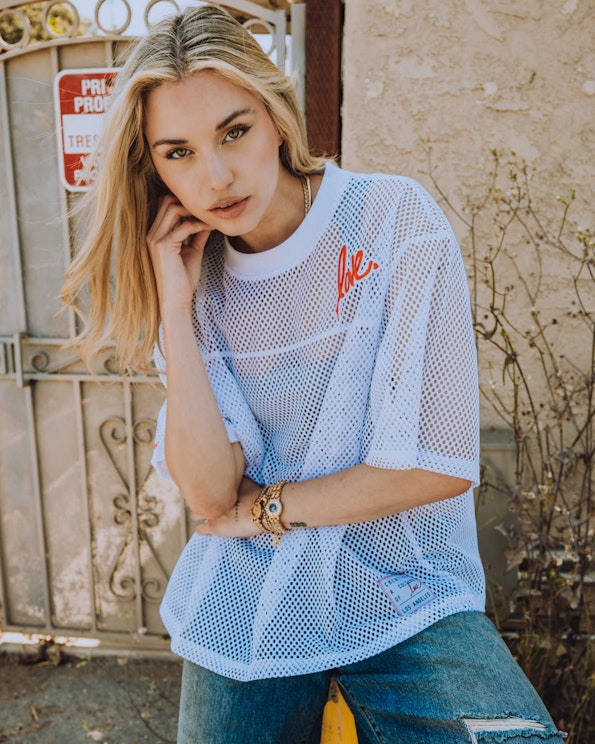 Full custom white mesh unisex jersey with red cursive "love" logo and Los Angeles label, produced by MerchCamp for Ruben Rojas