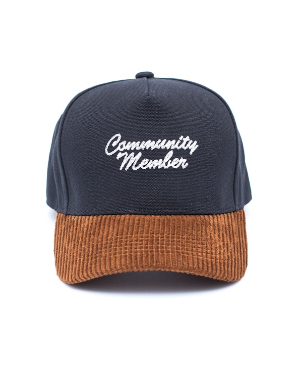 Embroidered black canvas snapback with brown corduroy brim and script lettering, produced by MerchCamp for Community Member