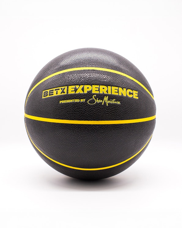 Custom black rubber basketball with yellow channel lines and printed branding, produced by MerchCamp for League Twenty Two
