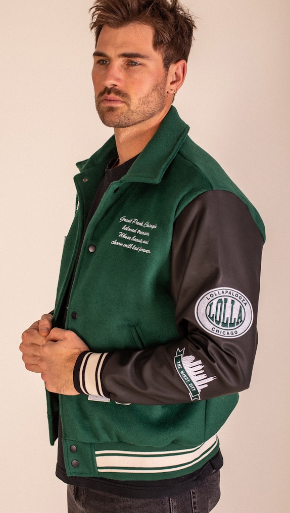 Male model wearing green and black Lollapalooza Chicago varsity jacket with leather sleeves, custom merchandise by MerchCamp