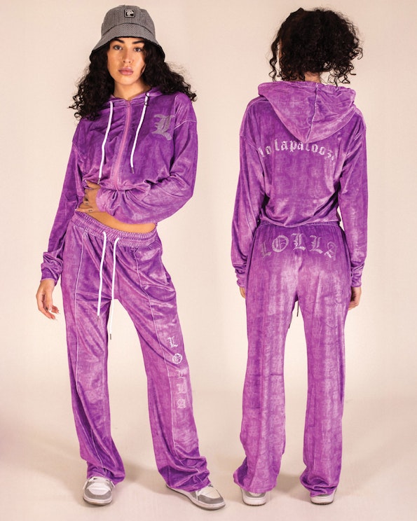 Full custom purple velour tracksuit with rhinestone gothic lettering and white drawstrings, produced by MerchCamp for Lollapalooza
