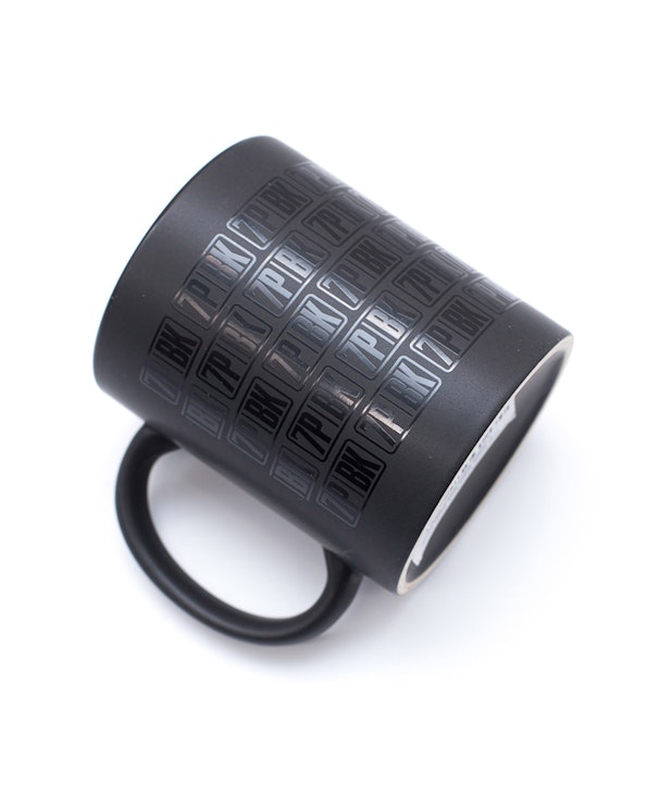 Custom matte black ceramic mug with tonal glossy repeated logo pattern, produced by MerchCamp for Wave Sports + Entertainment