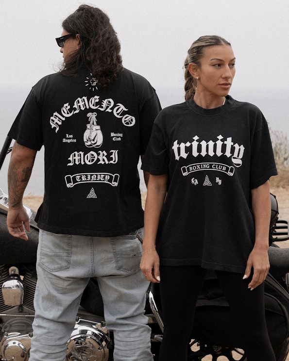 Screen printed black cotton boxing tee with Old English gothic lettering and glove graphic, produced by MerchCamp for Trinity Boxing