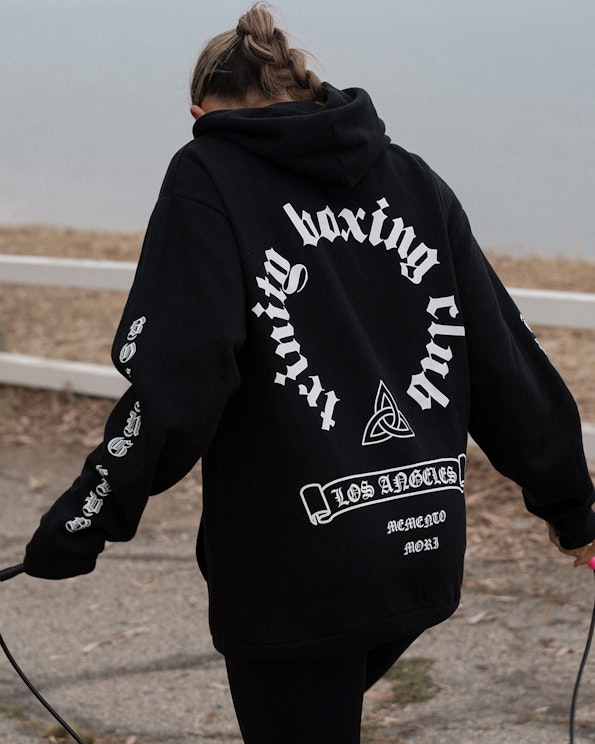 Screen printed black oversized fleece hoodie with Old English circular text and Celtic knot, produced by MerchCamp for Trinity Boxing