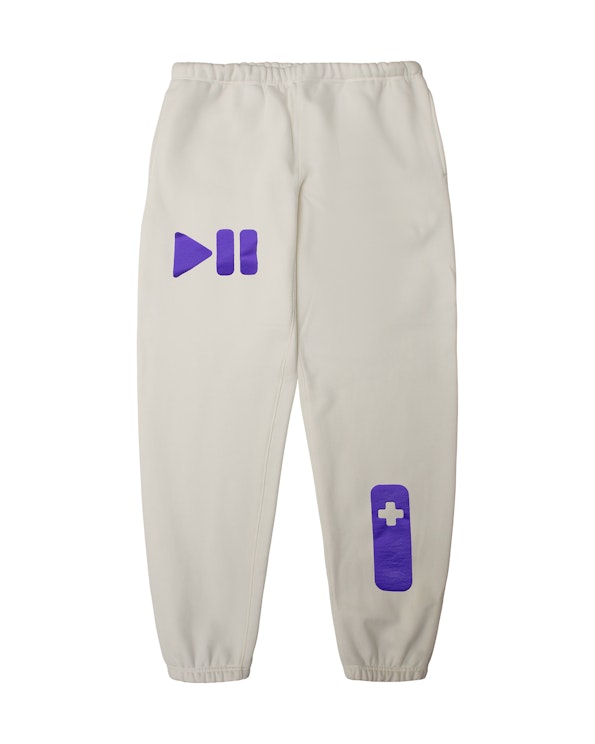 Puff printed cream fleece sweatpants with purple play/pause and D-pad gaming graphics, produced by MerchCamp for Roku