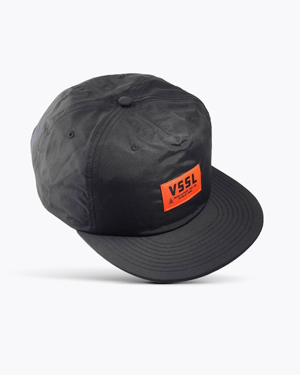 Custom black nylon surf cap with orange woven VSSL brand label patch, produced by MerchCamp for VSSL Gear