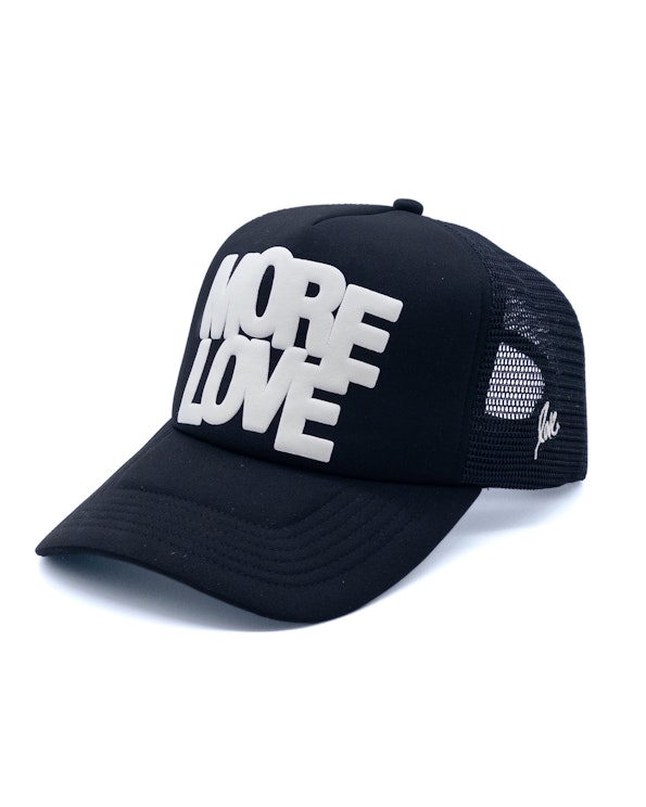 Puff printed black mesh trucker hat with raised white "More Love" lettering, produced by MerchCamp for Ruben Rojas