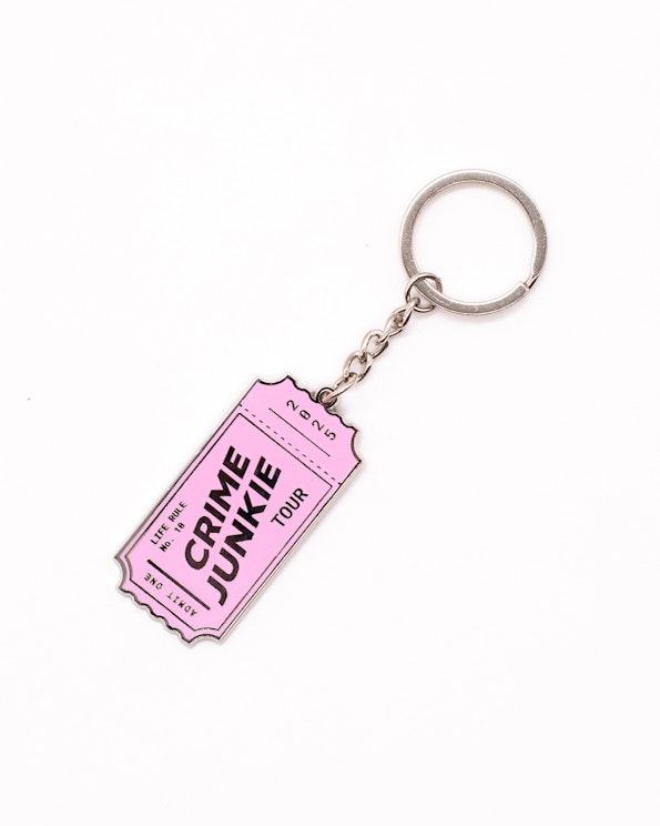 Full custom pink enamel ticket-shaped keychain with black text and silver split ring, produced by MerchCamp for Audiochuck
