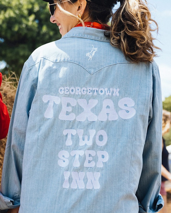 Full custom light-wash denim western shirt with puff print lettering and bull rider graphic, produced by MerchCamp for Live Nation
