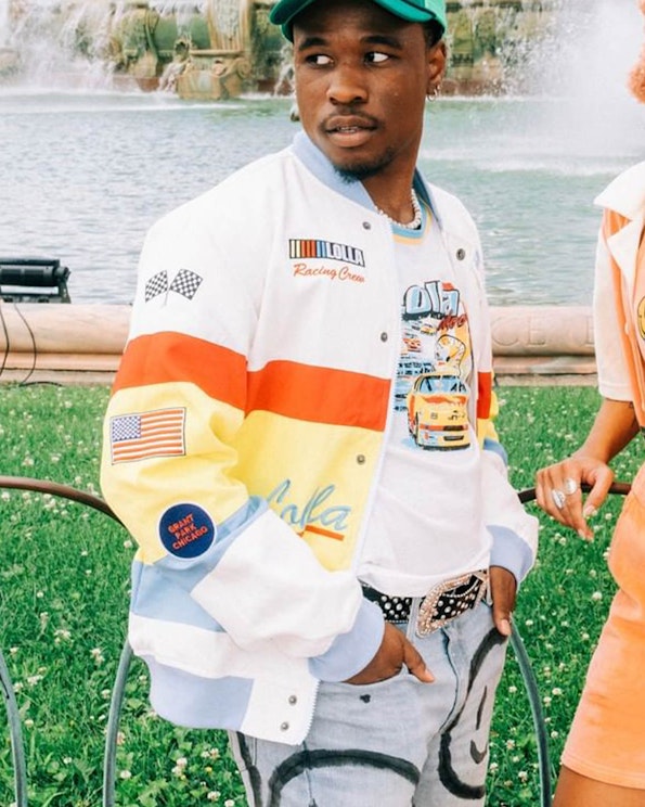 Full custom white racing jacket with orange-yellow stripes, checkered flags, and snap buttons, produced by MerchCamp for Lollapalooza