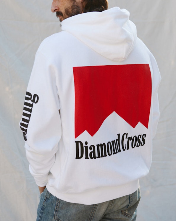 Screen printed white pullover hoodie with red mountain graphic and black serif text, produced by MerchCamp for Diamond Cross Ranch