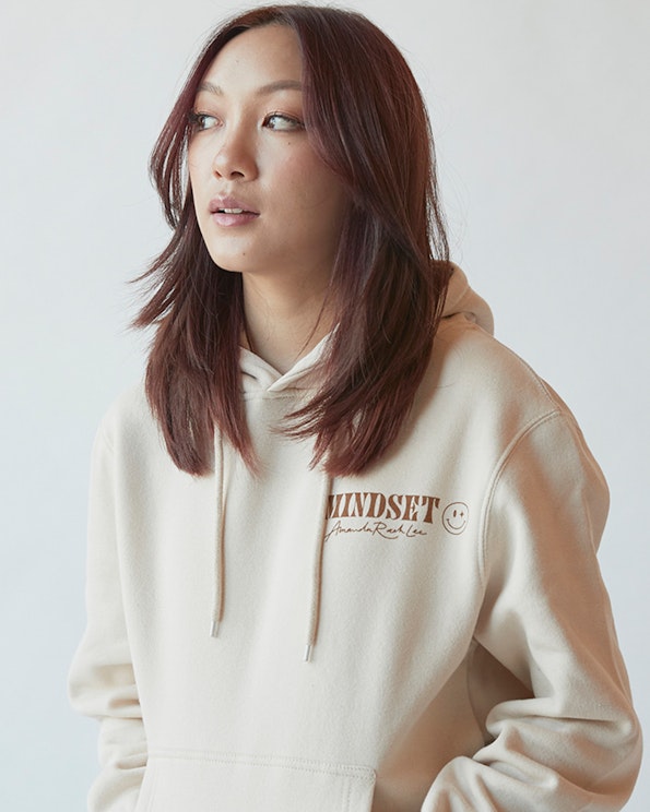 Screen printed cream fleece pullover hoodie with brown serif text and smiley motif, produced by MerchCamp for Mindset