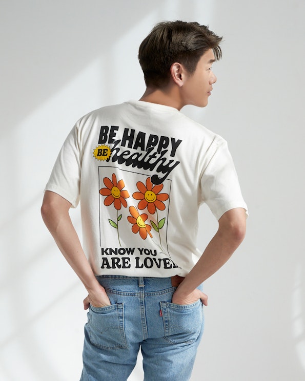 Screen printed cream cotton oversized tee with retro smiley flower graphic and bold text, produced by MerchCamp for Mindset