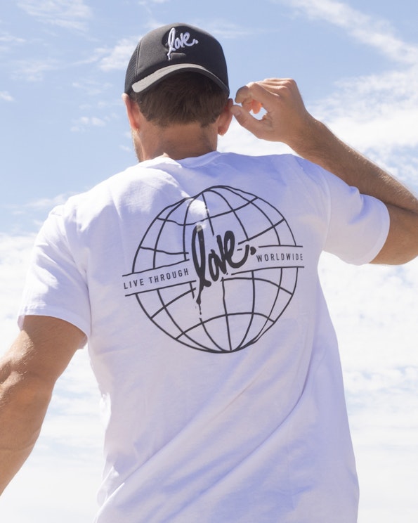 Screen printed white cotton tee with black globe graphic and cursive love script, produced by MerchCamp for Ruben Rojas