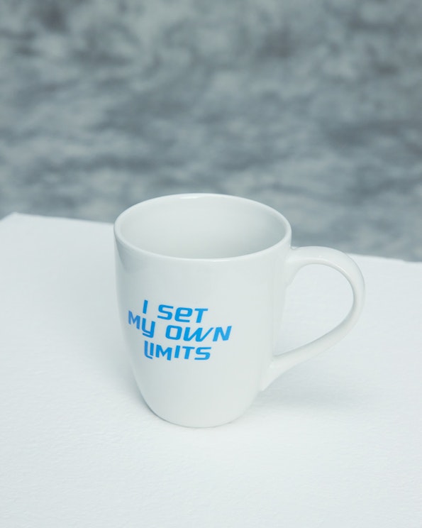 Custom printed white ceramic mug with blue motivational text "I Set My Own Limits, produced by MerchCamp for Mindset