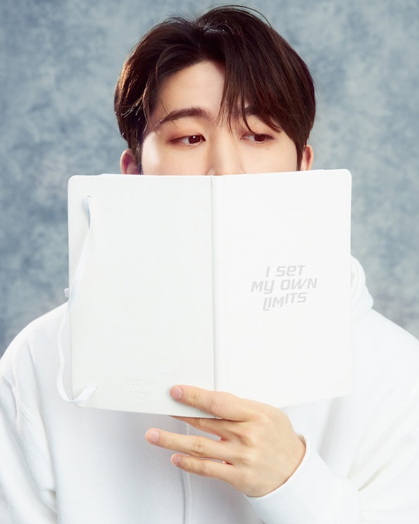 Custom printed white faux leather journal with embossed motivational quote text, produced by MerchCamp for Mindset