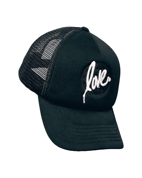 Embroidered black foam trucker hat with white script "love" globe logo and mesh back, produced by MerchCamp for Ruben Rojas