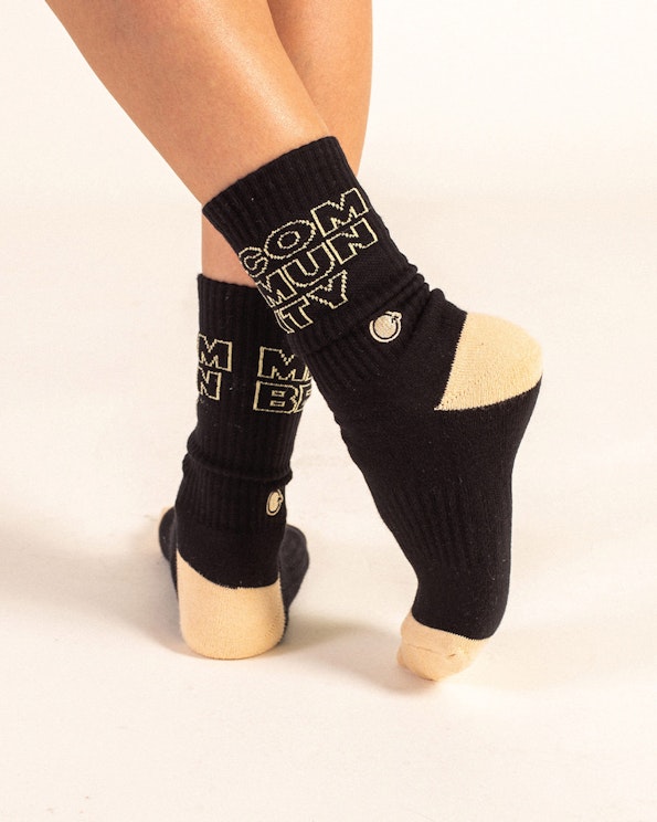 Full custom black ribbed knit crew socks with cream heel and toe accent, produced by MerchCamp for Community Member