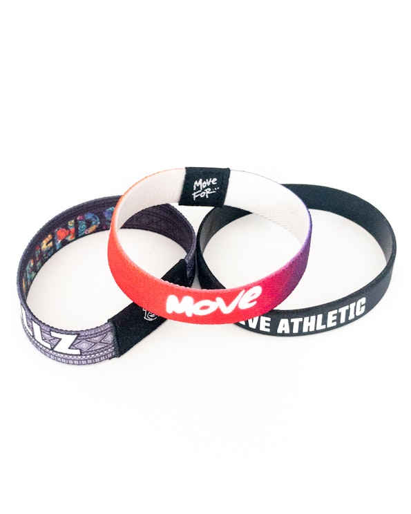 Custom printed fabric wristbands in red gradient, black, and multicolor aztec designs, produced by MerchCamp