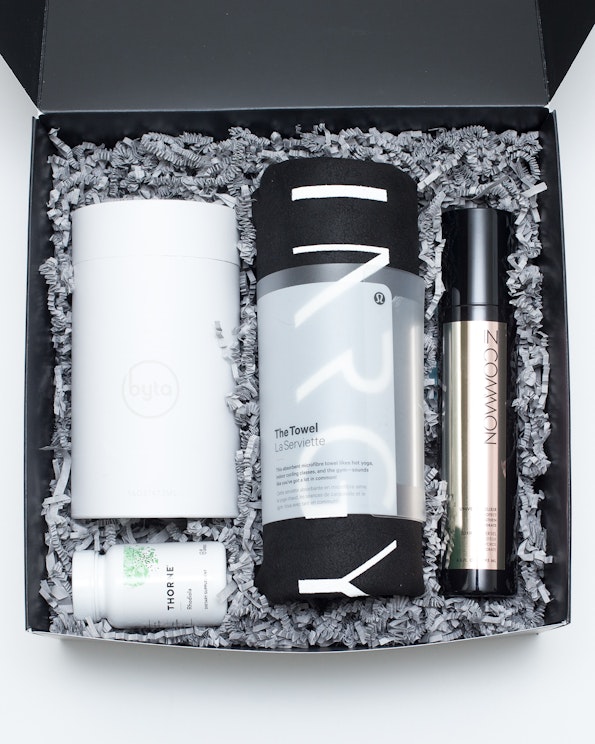 Custom curated PR kit with branded white Byta tumbler, Lululemon towel, and skincare elixir, produced by MerchCamp for KINRGY