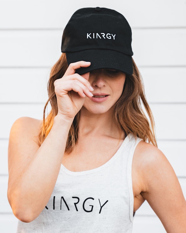 Embroidered black cotton dad hat with white sans-serif logo on front panel, produced by MerchCamp for KINRGY