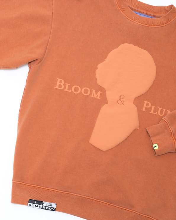 Puff printed rust crewneck sweatshirt with tonal raised silhouette and serif lettering, produced by MerchCamp for Bloom & Plume