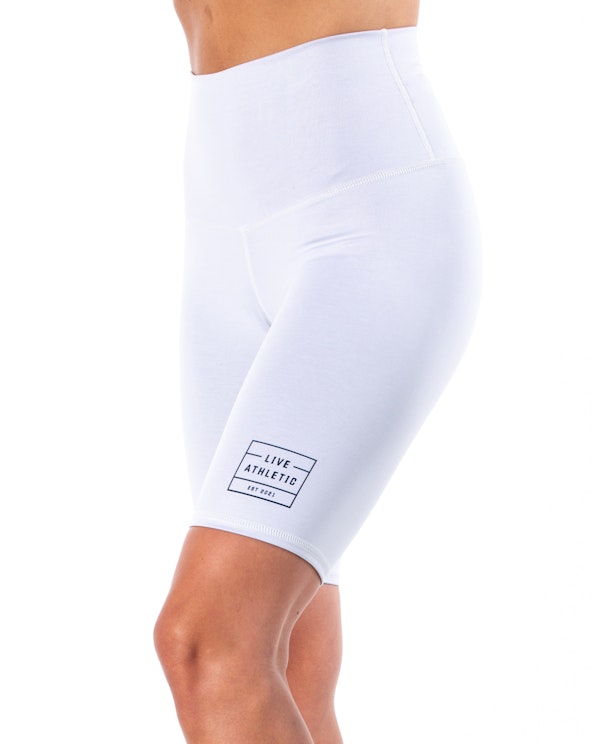 Custom white high-waisted bike shorts with printed logo detail and stretch fabric, produced by MerchCamp for Live Athletic