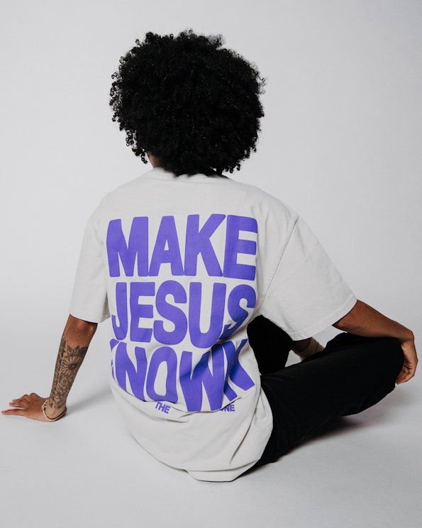 Puff printed oversized cream cotton tee with bold purple back graphic lettering, produced by MerchCamp