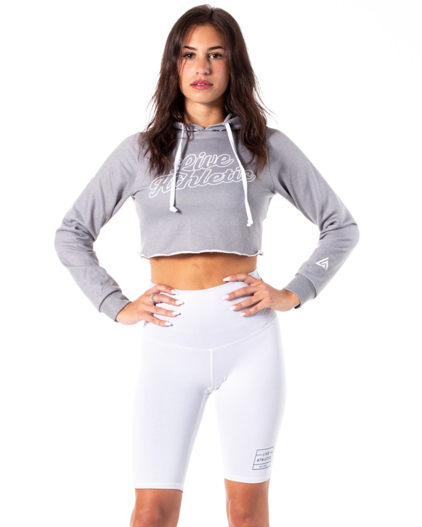 Custom heather grey cropped fleece hoodie with white script lettering and raw hem, produced by MerchCamp for Live Athletic