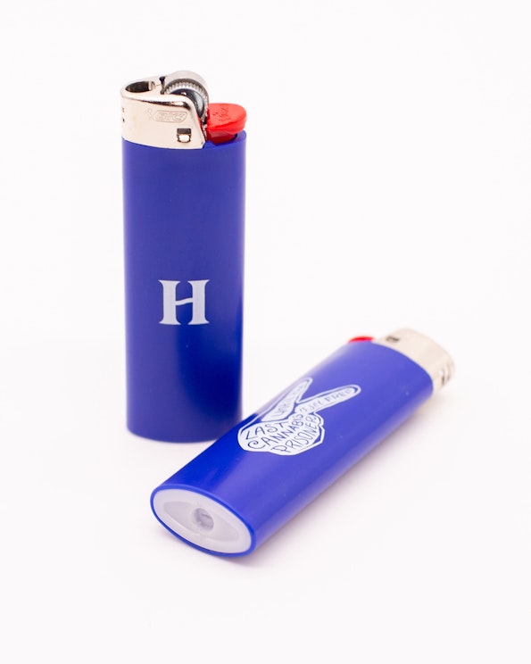 Custom blue Bic lighter with white H monogram and peace sign graphic, produced by MerchCamp for Herb