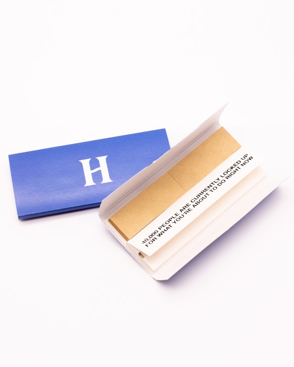 Custom blue and white rolling papers booklet with printed text and brown filter tips, produced by MerchCamp for Herb
