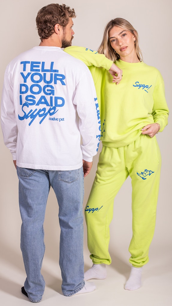 Two models wearing branded Native Pet "Supp" merchandise including white long-sleeve tee and neon, custom merchandise by MerchCamp