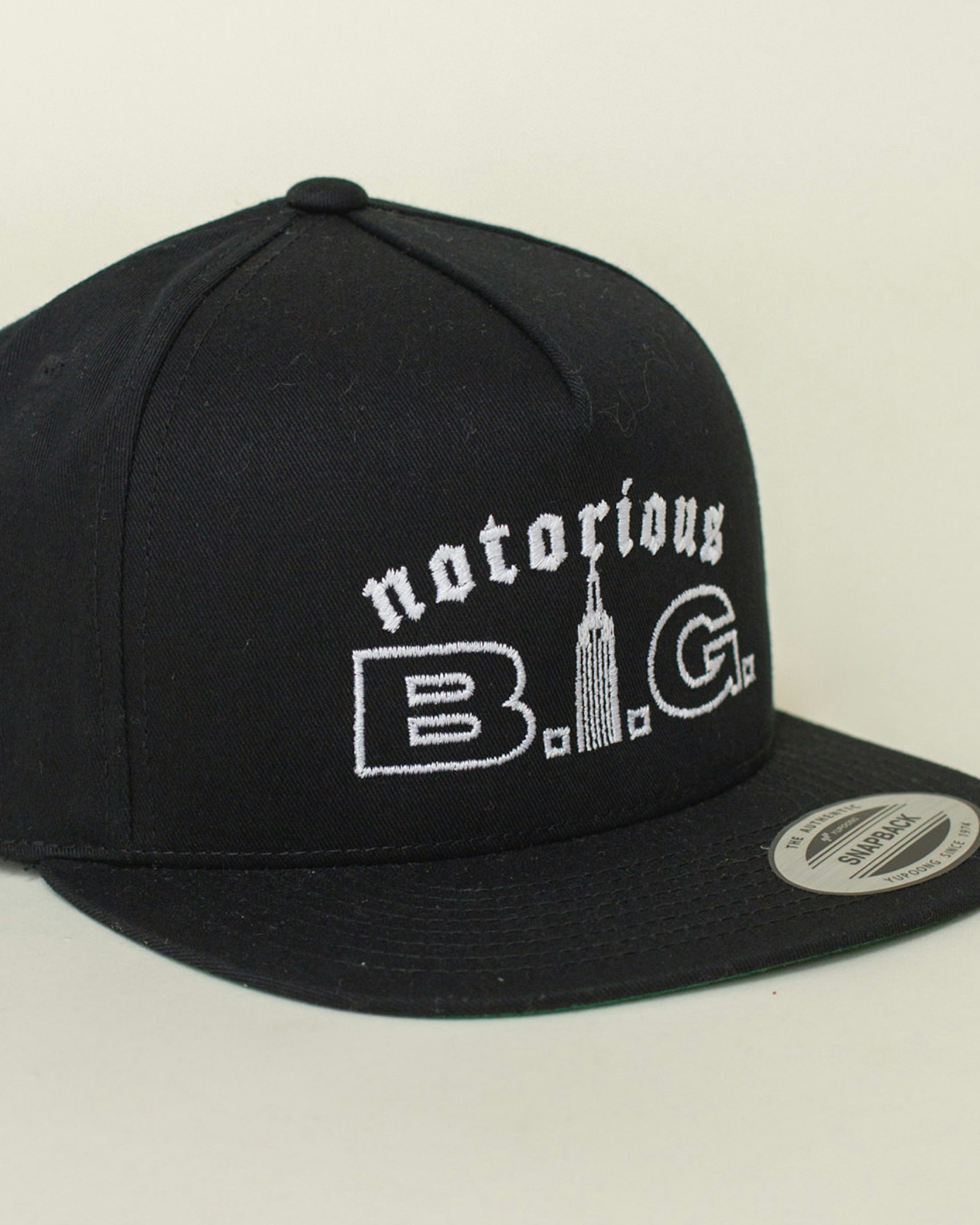 Black Notorious B.I.G. snapback hat with white embroidered text and Empire State Building — Biggie Smalls merchandise by MerchCamp