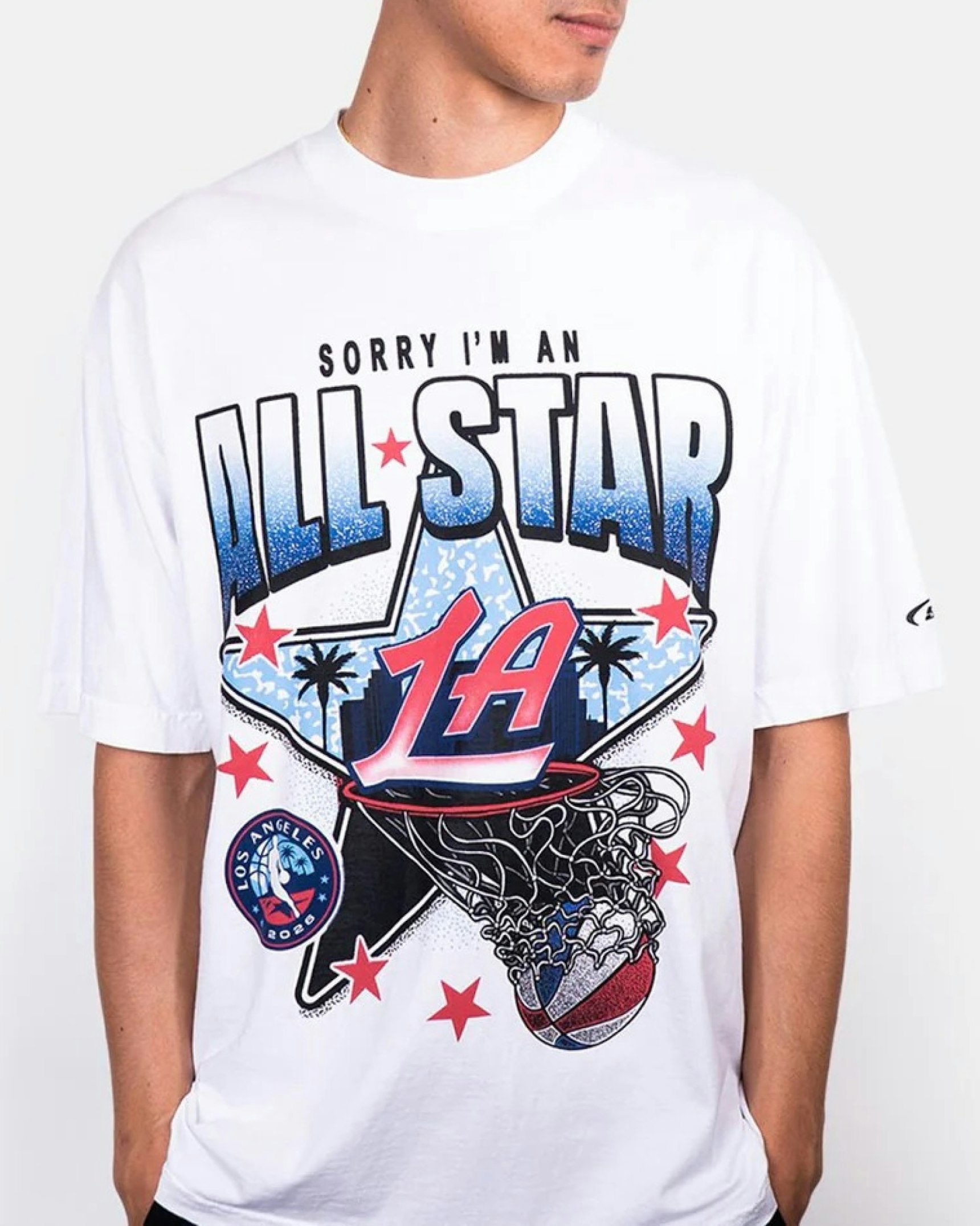 Man modeling white oversized NBA All-Star LA 2025 graphic tee with basketball hoop design — LA Clippers merchandise by MerchCamp