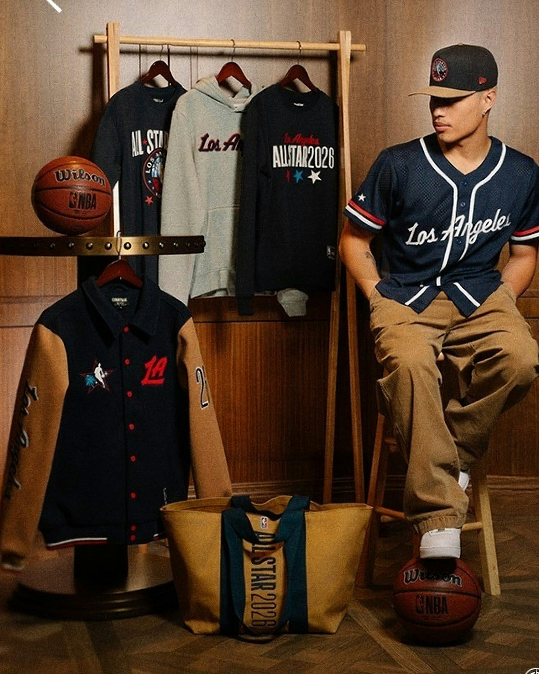 Model in navy Los Angeles baseball jersey posing with NBA All-Star 2026 merchandise collection — LA Clippers merchandise by MerchCamp