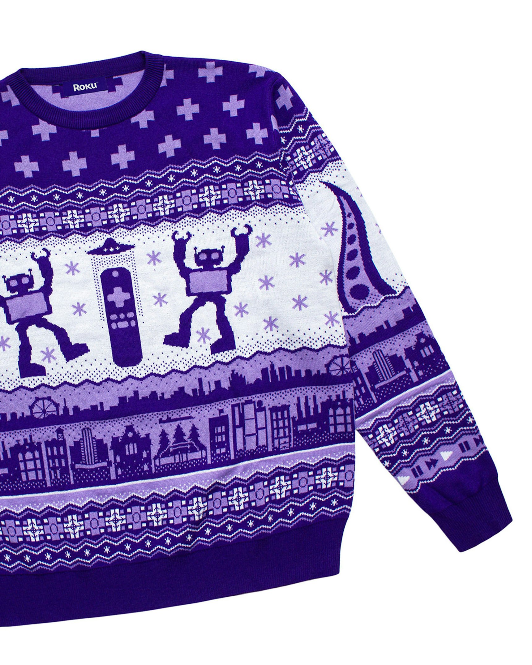 Purple and white Roku branded ugly Christmas sweater featuring pixel-art robots, snowflakes, — Roku merchandise by MerchCamp