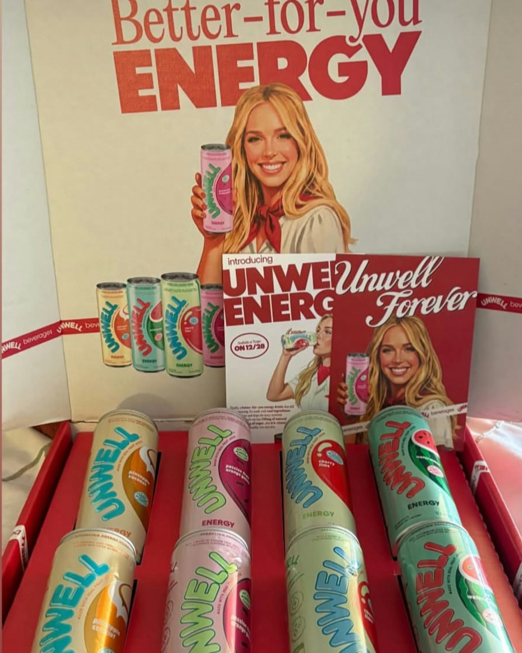 Unwell Energy drink PR box with colorful cans, promotional cards, and branded packaging displayed — Unwell merchandise by MerchCamp