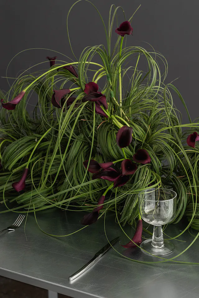 Uma mesa-instalação apenas com callas e folhagens dos pampas.