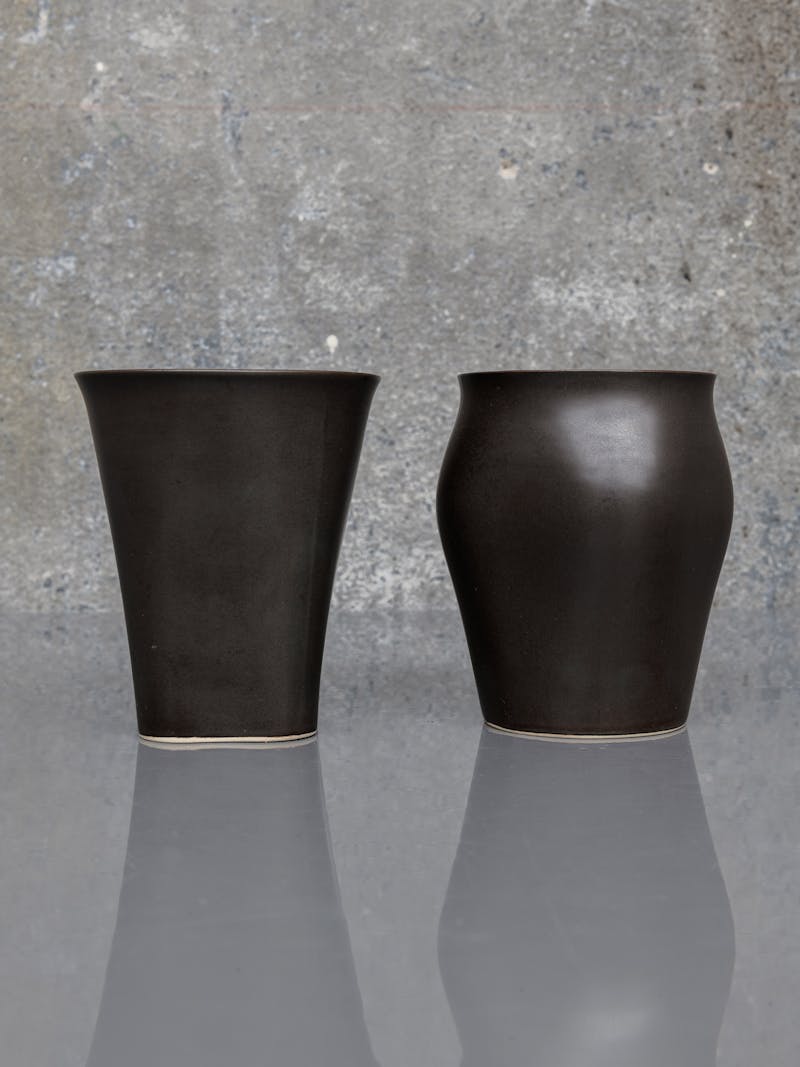 Black and white image displaying Cup One and Two by Maria Tyakina. The ceramic cups are black and are part of the new 2024 spring collection 'Observations' by online gallery Metamorphoses Objects.