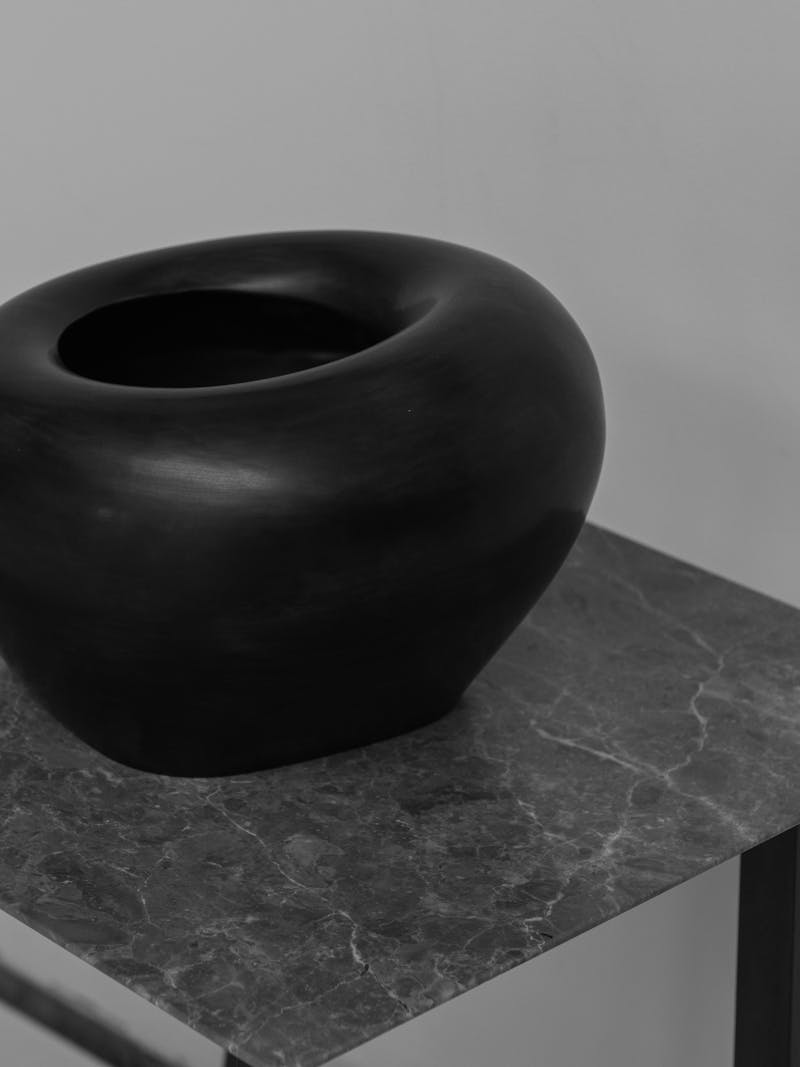 Black and white image displaying Flexible Formed Vase in black by Rino Claessens. This ceramic object is part of the new 2024 spring collection 'Observations' by online gallery Metamorphoses Objects.