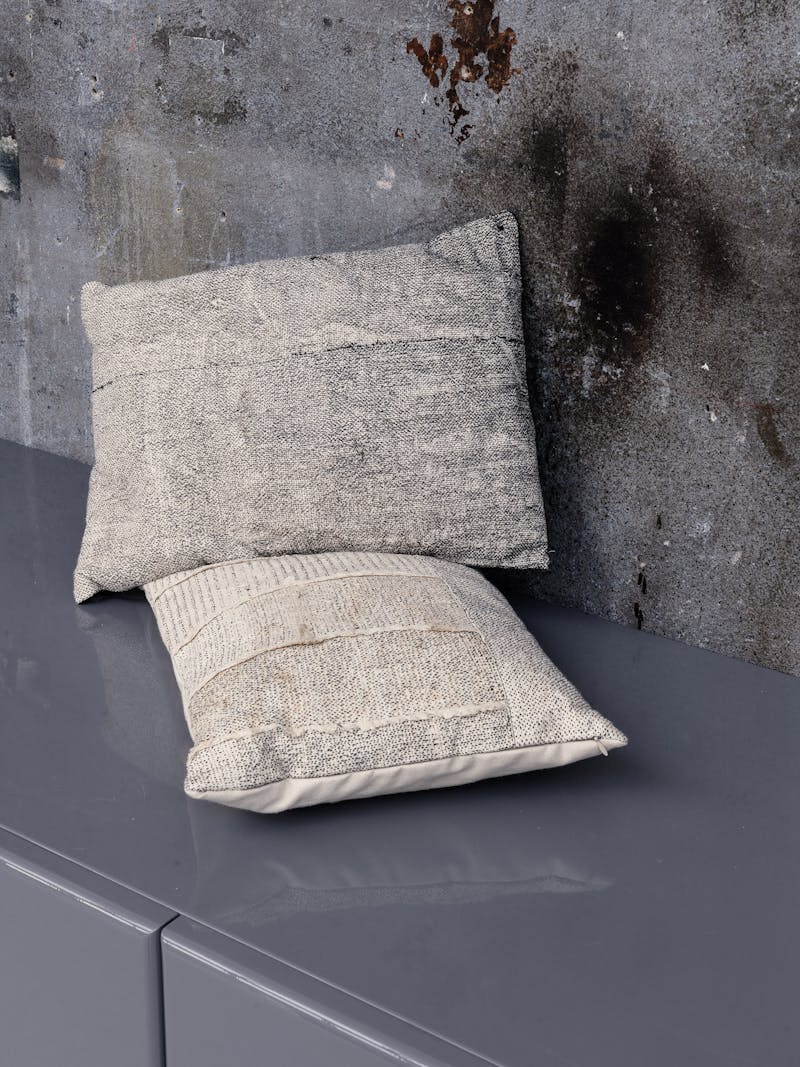 Colour image displaying the Wooden Textile Pillows in grey by material studio Buro Belén. These unique, homeware items are part of the new 2024 spring collection 'Observations' by online gallery Metamorphoses Objects. 