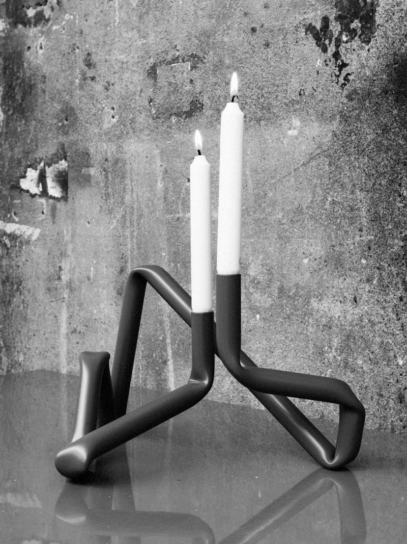 Black and white image of the handmade Bucatini aluminium candle holder in green matte by Danish design studio A.O.T. The object is part of the new 2024 spring collection 'Observations' by online gallery Metamorphoses Objects.
