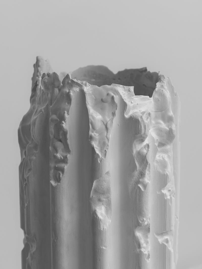 Black and white image displaying close-up detail of Cornice Vessel in cream by Lenny Stöpp. The column vase is moulded from alpha crystalline gypsum using the cornice vessel technique. This item is part of the new 2024 spring collection 'Observations' by online gallery Metamorphoses Objects.