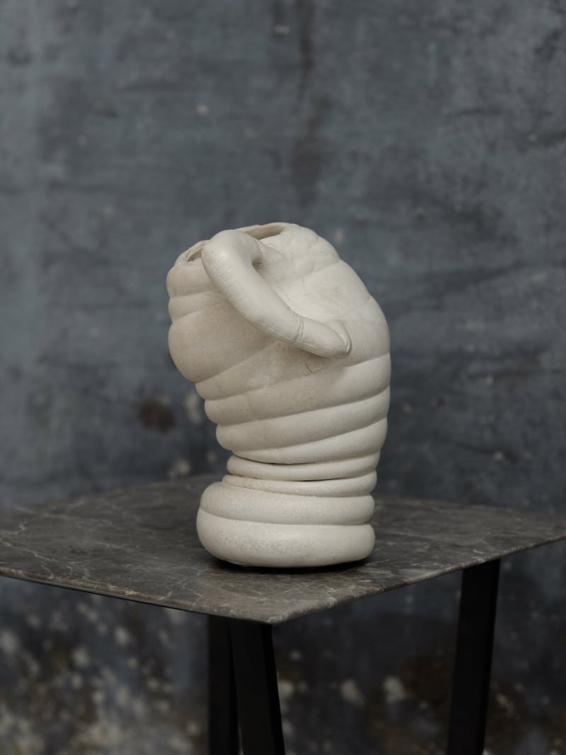 Colour image displaying Chub Vase III by Tessa Silva. The vase is white and the body contains horizontal lines and a handle. The material is made using the 'Chalk & Cheese' technique which is produced by manipulating proteins in fermented skimmed milk. This object is exclusively made for the new 2024 spring collection 'Observations' by online gallery Metamorphoses Objects.
