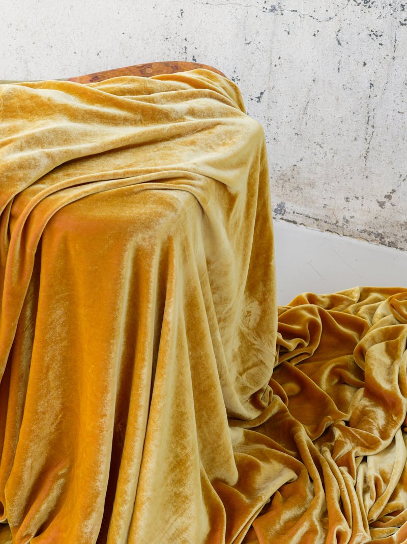 Colour image displaying details of Velvet Blanket in ochre by material studio Buro Belén. This item is part of the new 2024 spring collection 'Observations' by online gallery Metamorphoses Objects.