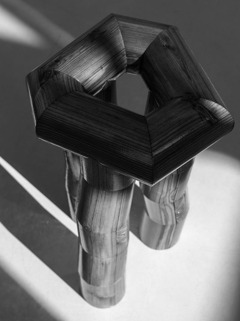 Black and white image displaying Segmento Stool by Cara/Davide, made from pine wood. This unique, design chair is part of the new 2024 spring collection 'Observations' by online gallery Metamorphoses Objects.