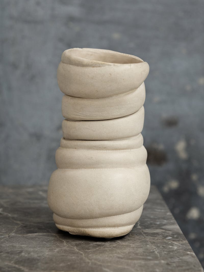 Colour image displaying far shot of Chub Vase II by Tessa Silva. The vase contains horizontal lines and a handle. The material is made using the 'Chalk & Cheese' technique which is produced by manipulating proteins in fermented skimmed milk. This object is exclusively made for the new 2024 spring collection 'Observations' by online gallery Metamorphoses Objects.