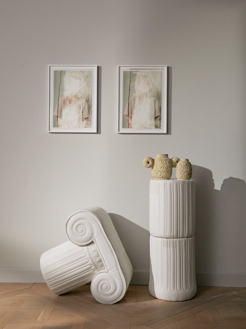 An ionic pillar or pedestal in three pieces created from off white linen by Spanish artist and designer Sergio Roger.  Sitting on top of the pillar is two works by Pauline Bonnet and two wall works by Amsterdam based artist Amie Dicke in the background. 