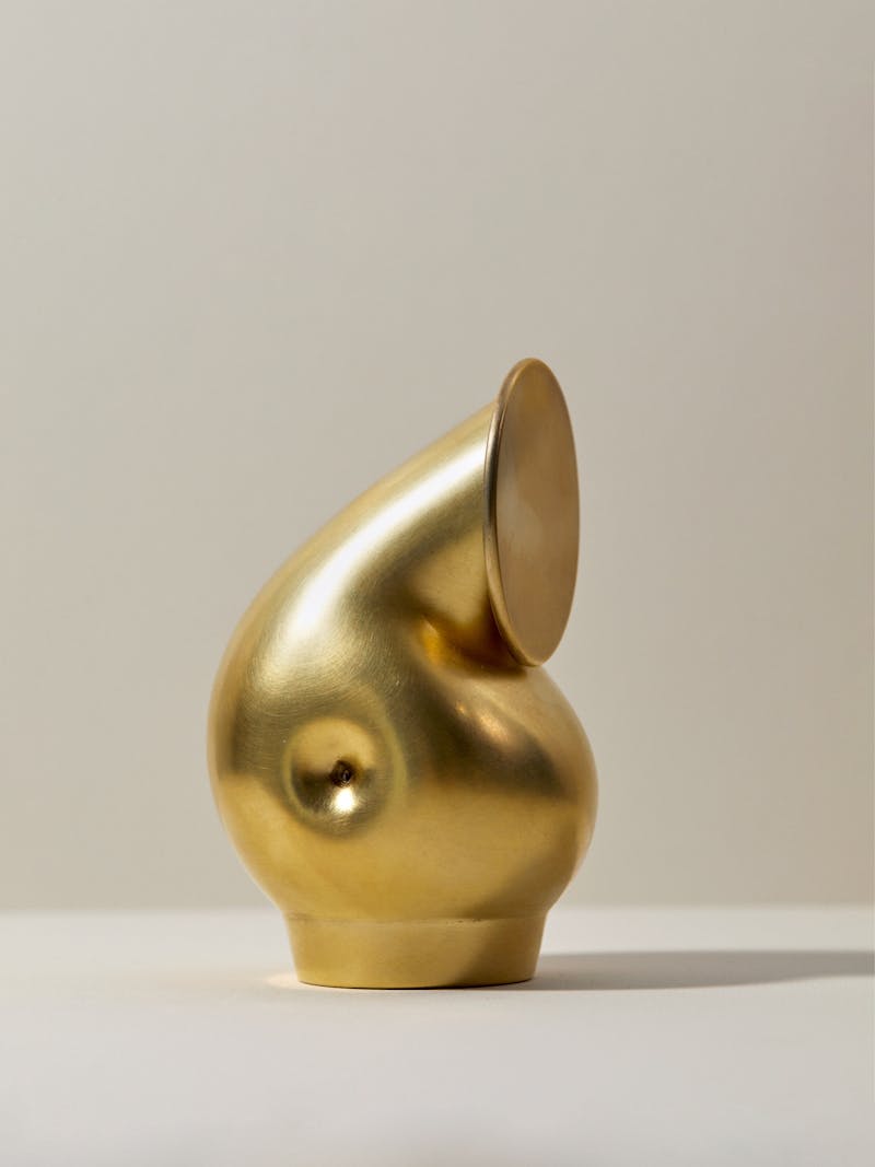 unique and hand crafted gold plated silver vessel with a pivoting lid and a shell like shape. The vessel is by Dutch designer Aldo Bakker. 
