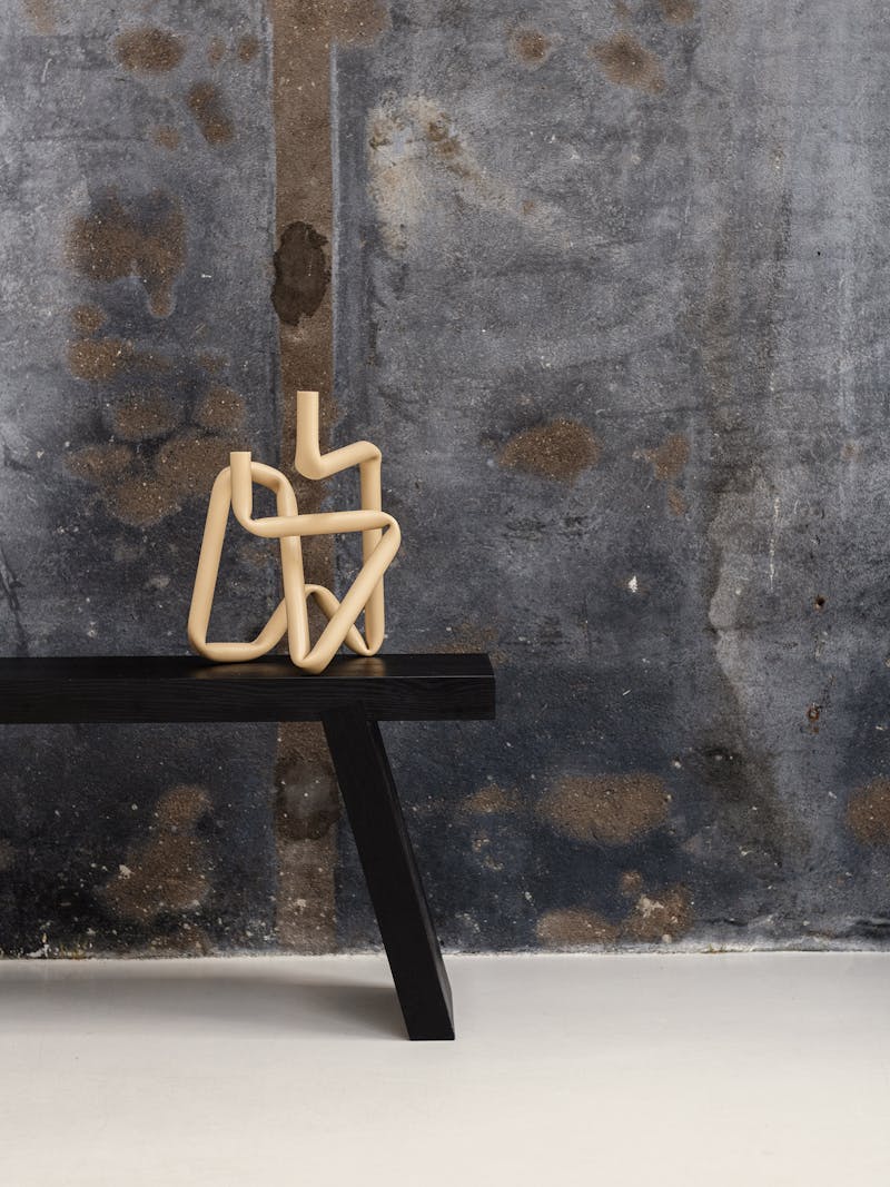 colour image of the handmade Bucatini aluminium candle holder in shiny beige (large) by Danish design studio A.O.T. The object is part of the new 2024 spring collection 'Observations' by online gallery Metamorphoses Objects.